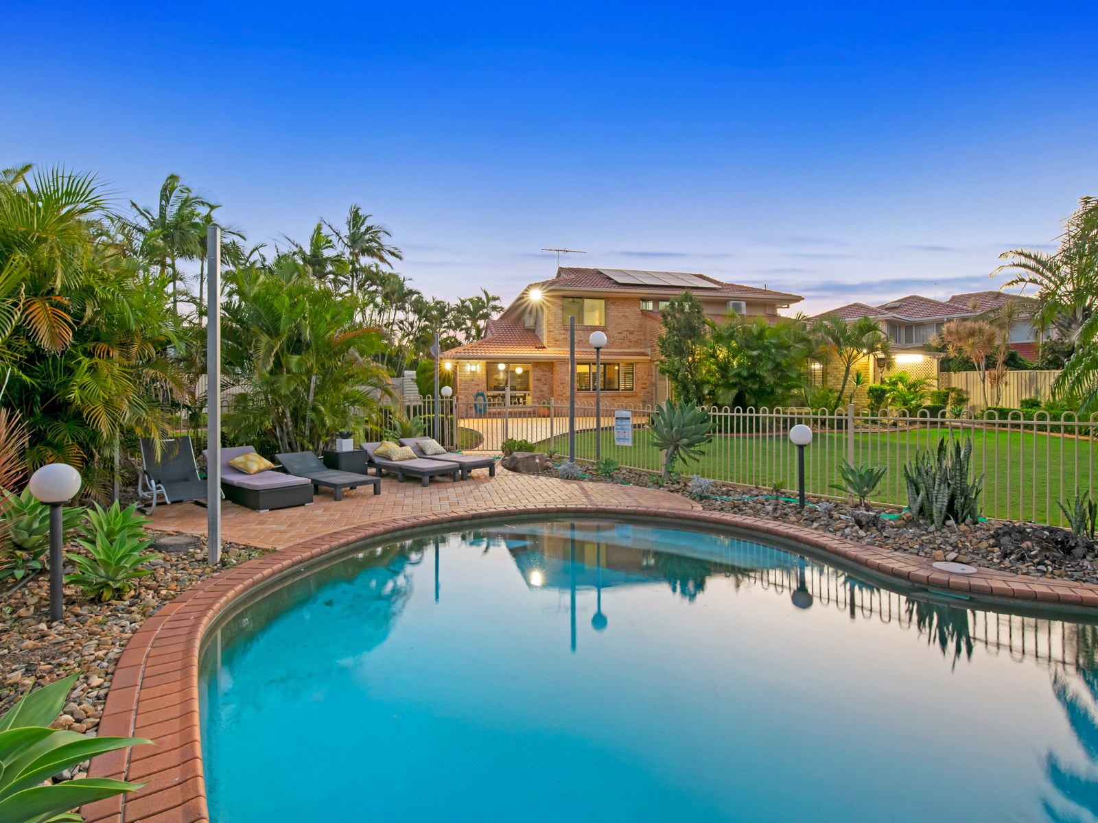 Resort-style pool at twilight with the home behind