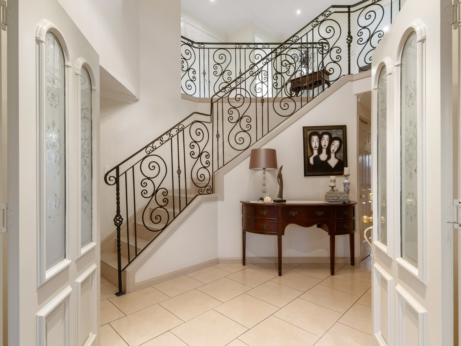 Grand entry with wrought iron staircase