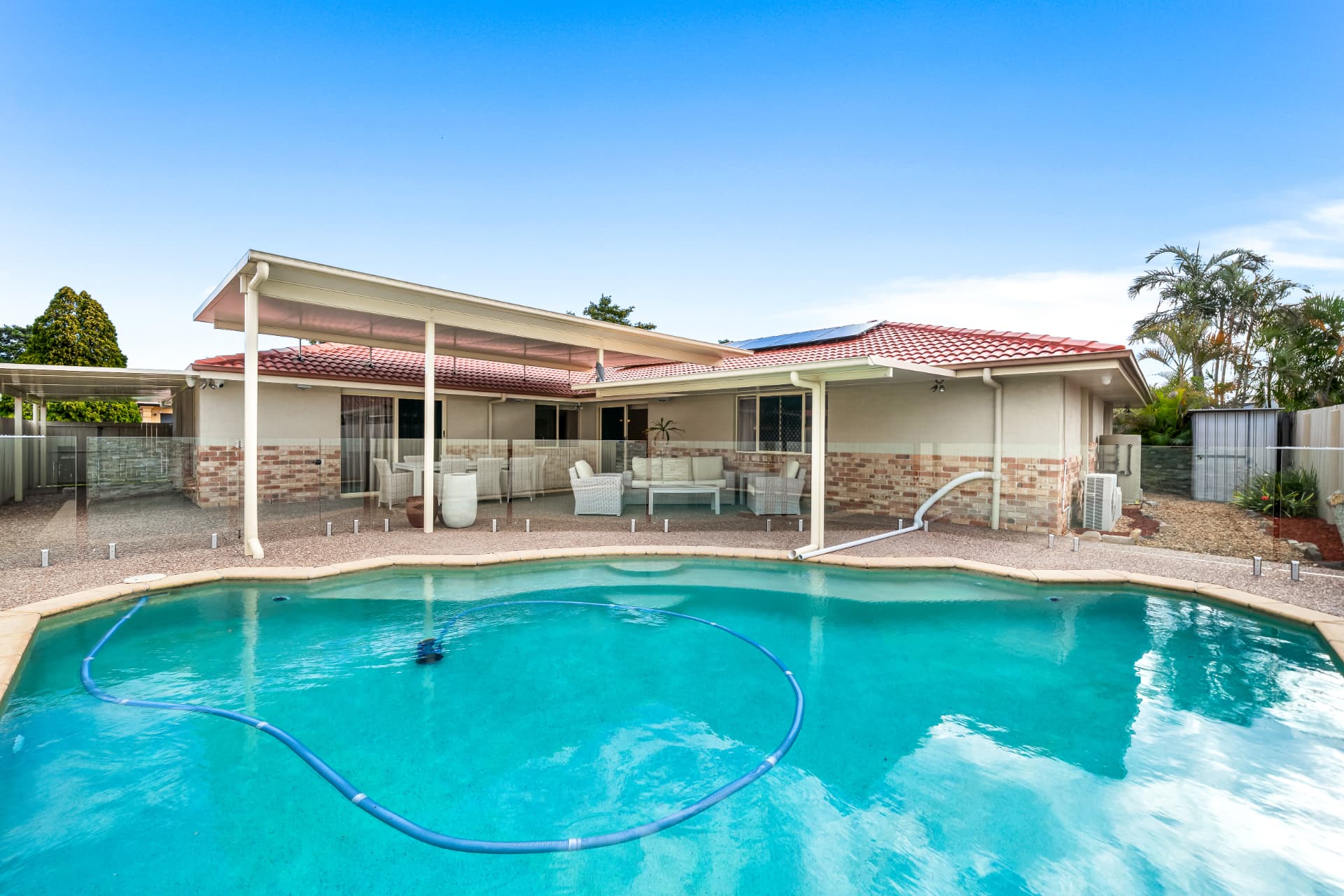In ground pool with glass fencing and covered patio at 27 Greenhaven Crescent Kuraby